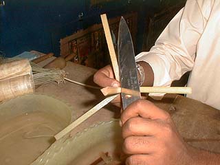 Entfernen der Außenhaut des Papyrusstängels mit einem Messer