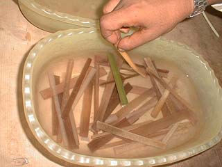 Papyrus strips soaking in a bowl of water
