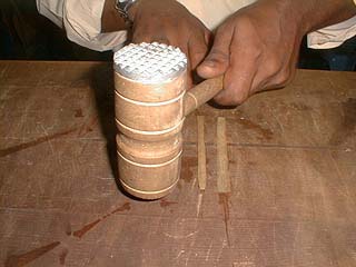 Flattening the papyrus strips with a wooden mallet