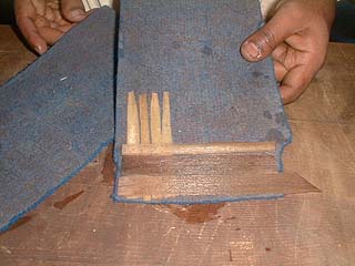 Arranging the rolled papyrus strips on a felt cloth in a checkerboard pattern